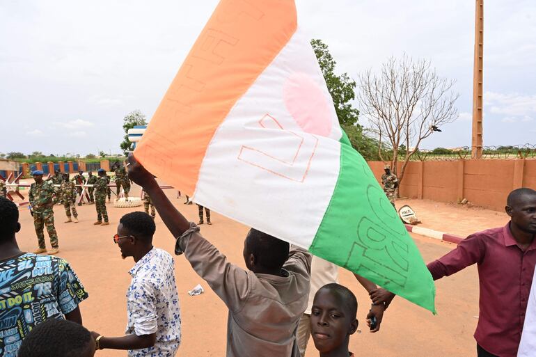 Partidarios del Consejo Nacional para la Salvaguardia de la Patria de Níger ondean la bandera mientras se reúnen para una manifestación en Niamey.