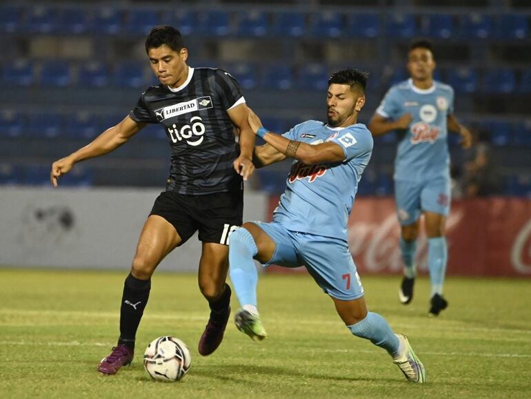 Lorenzo Melgarejo (i), futbolista de Libertad, y Richard Salinas (d), jugador de Resistencia. pelean por el balón en el duelo por la segunda fecha del torneo apertura 2023 del fútbol paraguayo en el estadio Luis Alfonso Giagni.