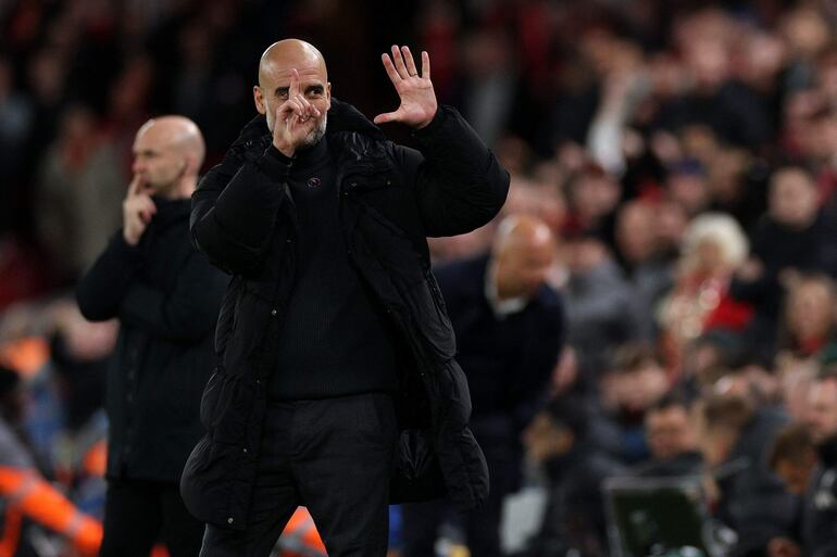 TOPSHOT - Manchester City's Spanish manager Pep Guardiola reacts to Liverpool fans chanting jeers during the English Premier League football match between Liverpool and Manchester City at Anfield in Liverpool, north west England on December 1, 2024. (Photo by Adrian Dennis / AFP) / RESTRICTED TO EDITORIAL USE. No use with unauthorized audio, video, data, fixture lists, club/league logos or 'live' services. Online in-match use limited to 120 images. An additional 40 images may be used in extra time. No video emulation. Social media in-match use limited to 120 images. An additional 40 images may be used in extra time. No use in betting publications, games or single club/league/player publications. / 