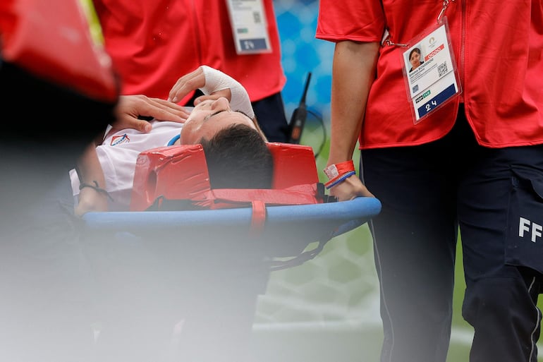 Enso González, jugador de la selección de Paraguay, deja el campo de juego en camilla a causa de una lesión en la rodilla derecha durante el partido frente a Israel por la segunda fecha del Grupo D del Torneo de Fútbol masculino de los Juegos Olímpicos París 2024 en el estadio Parque de los Príncipes, en París, Francia. 
