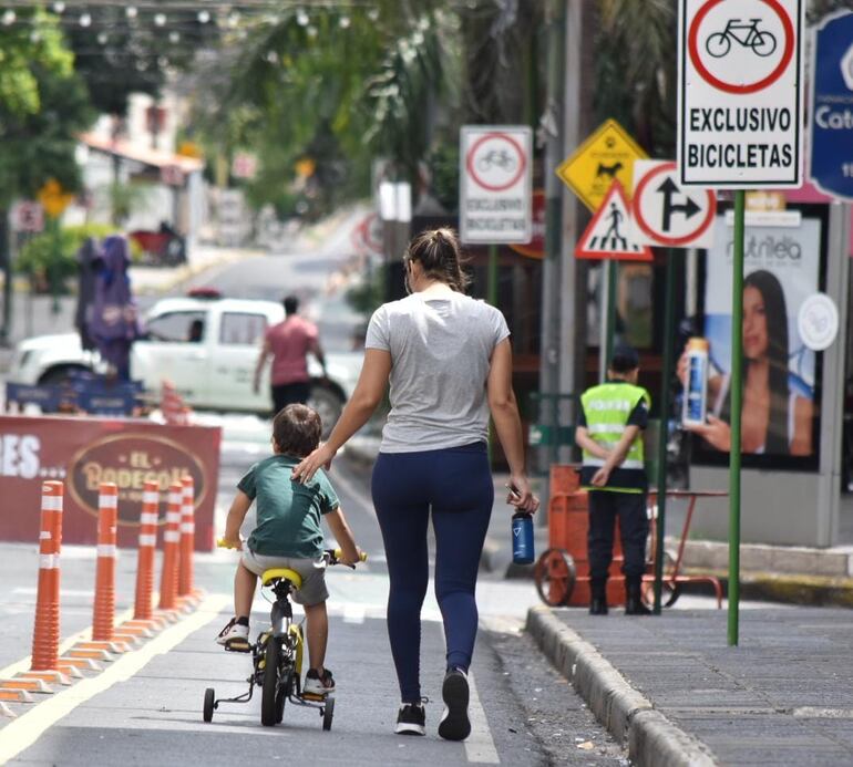 En la mañana de domingo, un niño acompañado por una adulta aprovecha el tramo de la bicisenda que corre sobre la calle Palma para andar en su bicicleta con rueditas.