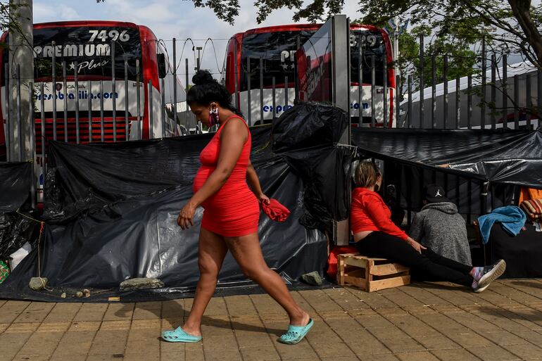 Migrantes venezolanos acampan fuera de una terminal de buses en Medellín, Colombia, esperando regresar a su país.