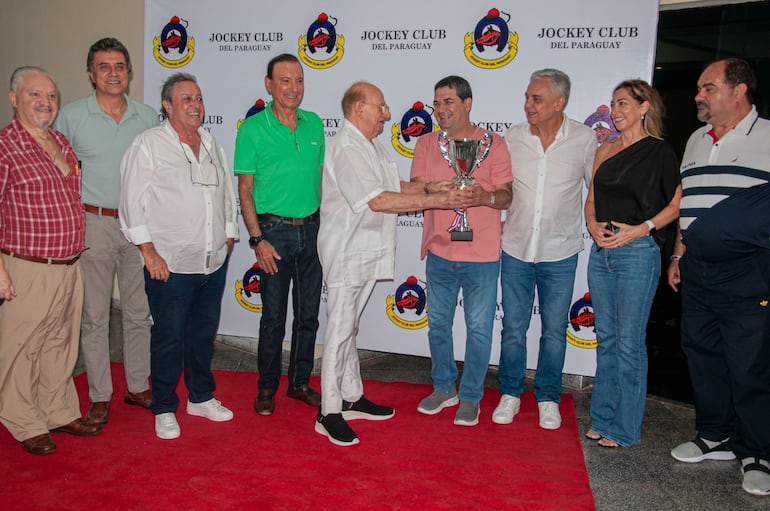 Papi Cartasso entrega el trofeo "Día de los Héroes" a Hugo Velázquez, propietario de Justina.