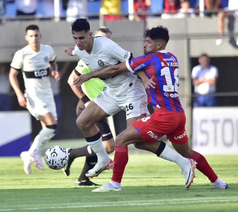 Kevin Parzajuk, autor de un gol en Olimpia, pelea el balón con Bruno Valdez, de Cerro Porteño, en el Superclásico.