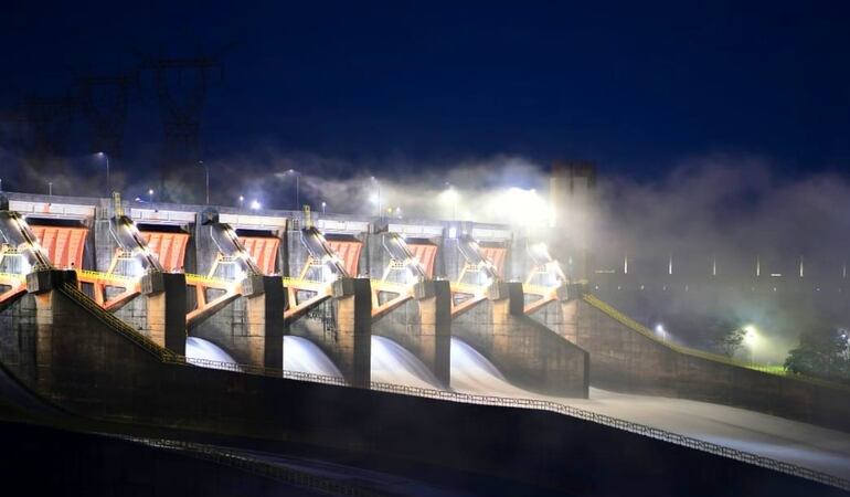 Vista nocturna de la represa de Itaipú con las compuertas abiertas.