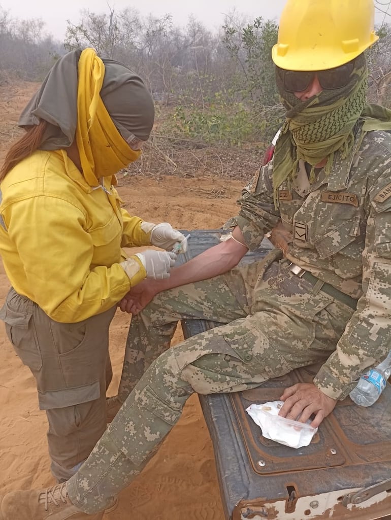 Una integrante de salud de la brigada Yaguareté presta asistencia sanitaria a un personal militar en la zona del incendio.