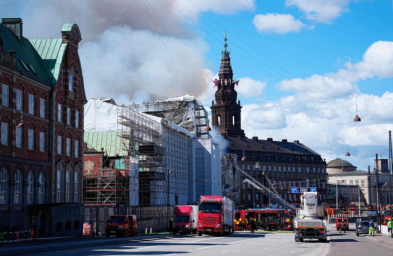 Los bomberos trabajan para extinguir el incendio del histórico edificio de la bolsa de valores de Boersen (C) en el centro de Copenhague, Dinamarca.