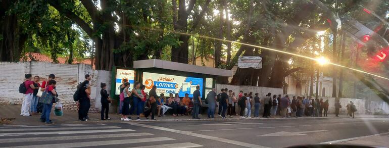 Una parada de buses ubicada sobre la Avda. Mariscal López que se encuentra copada por gente, lo que evidencia las reguladas aplicadas por los transportistas.