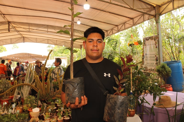 Julio Maidana, oriundo de Cabañas ofrece en su stand plantas de mburukuja rojo y morado.