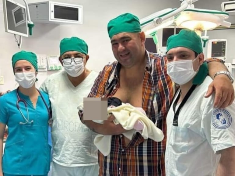 Jatar Fernández con su hija en brazos posa para la foto junto a profesionales de salud del Hospital Integrado de Ayolas.