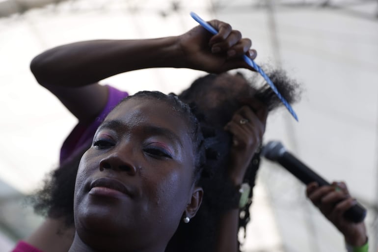 Una mujer es peinada durante el Festival Petronio Álvarez el 18 de agosto de 2023 en Cali (Colombia). Cuando las comunidades afro de la región Pacífico en Colombia temían a la muerte y los castigos de sus amos en la época de la esclavitud, surgió una estrategia que les dio la libertad y que se guardó como un secreto por muchos años: sus peinados. 