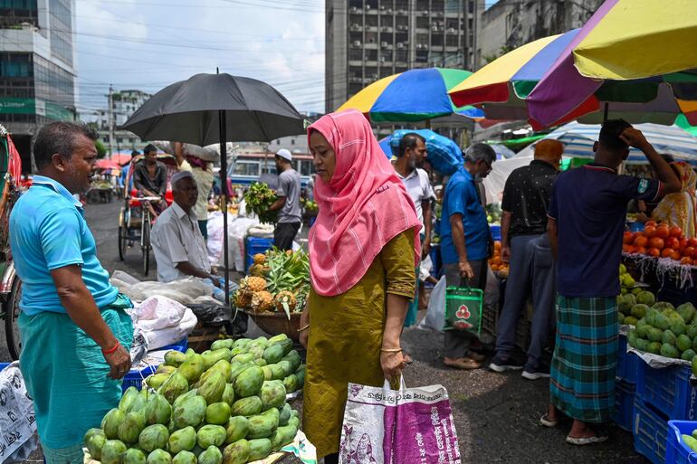 Vendedores de frutas y clientes en un mercado en Daca, este miércoles.
