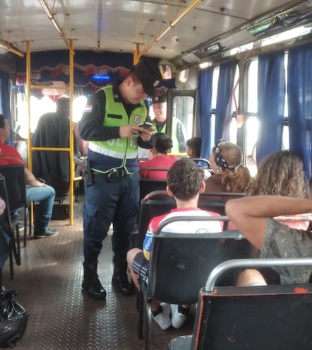 Un agente de la Policía Nacional realiza controles dentro de un colectivo.