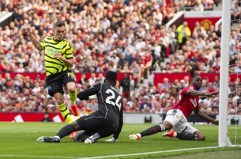 Manchester (United Kingdom), 12/05/2024.- Leandro Trossard of Arsenal (L) scores the 0-1 goal against goalkeeper Andre Onana of Manchester United (C) during the English Premier League soccer match between Manchester United and Arsenal in Manchester, Britain, 12 May 2024. (Reino Unido) EFE/EPA/PETER POWELL EDITORIAL USE ONLY. No use with unauthorized audio, video, data, fixture lists, club/league logos, 'live' services or NFTs. Online in-match use limited to 120 images, no video emulation. No use in betting, games or single club/league/player publications.
