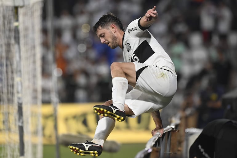 El uruguayo Alejandro Silva, jugador de Olimpia, salta el cartel publicitario después de celebrar un gol contra Nacional por la tercera fecha del torneo Clausura 2023 del fútbol paraguayo en el estadio Manuel Ferreira, en Asunción.