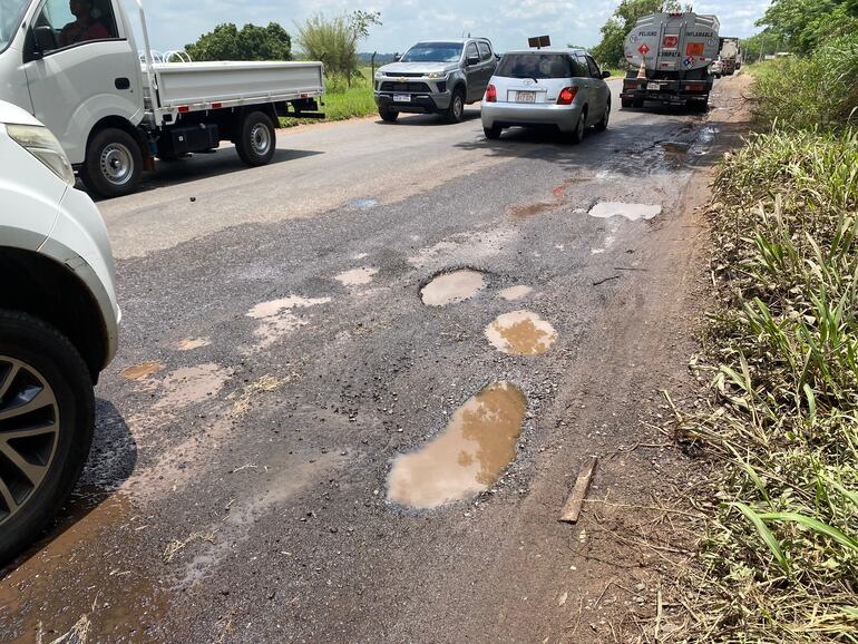 La ruta departamental D027, uno de los accesos al Aeropuerto Silvio Pettirossi, presenta baches y acumulación de agua, generando riesgos para conductores.