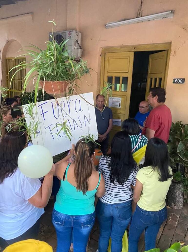 Uno de los carteles de los manifestantes piden que la secretaria de la parroquia salga.