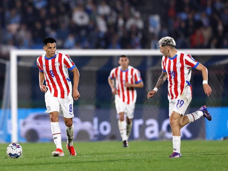 Diego Gómez (i) y Julio Enciso, jugadores de la selección de Paraguay, en el partido frente a Uruguay por la séptima fecha de las Eliminatorias Sudamericanas en el estadio Centenario, en Montevideo.