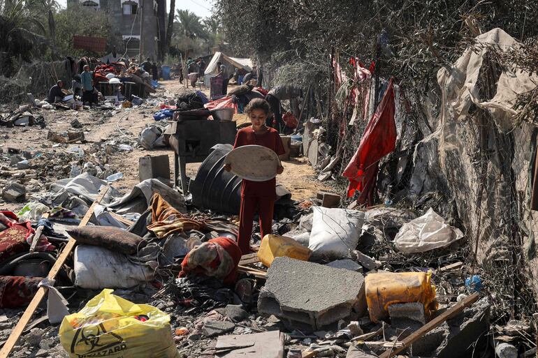 Una joven palestina recupera objetos de un edificio destruido, luego de un bombardeo israelí sobre Deir el-Balah, en la zona central de la Franja de Gaza.
