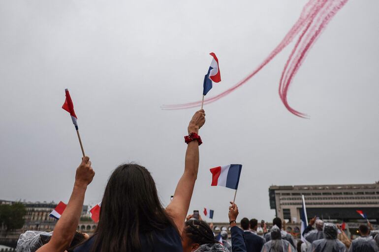 Atletas de la delegación francesa navegan en un bote por el río Sena. 