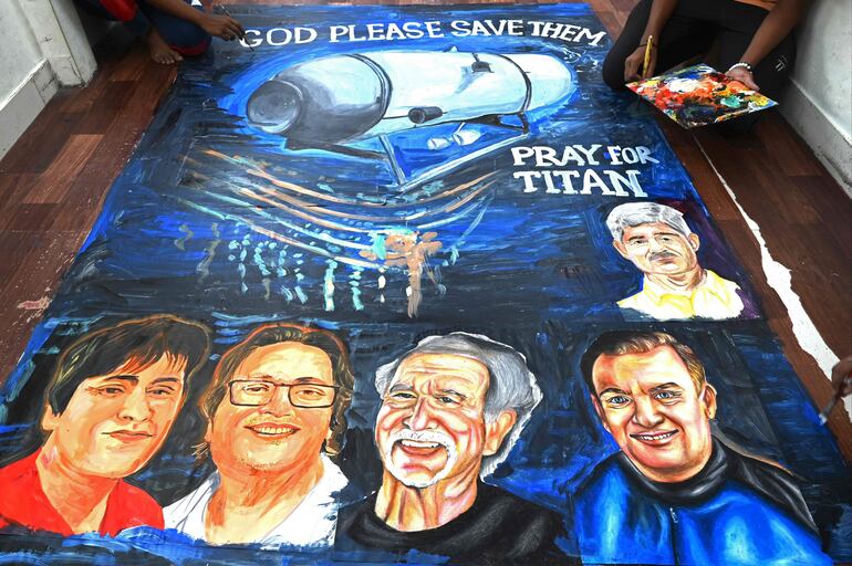 Los estudiantes de una escuela de arte dan los toques finales a una pintura que representa a las cinco personas a bordo de un sumergible llamado Titán, que desapareció cerca de los restos del Titanic, el 22 de junio de 2023.