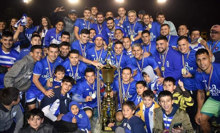 Los futbolistas rodean el  hermoso trofeo de campeón conquistado por el Unión Agrícola. Foto Cynthia Iglesias.