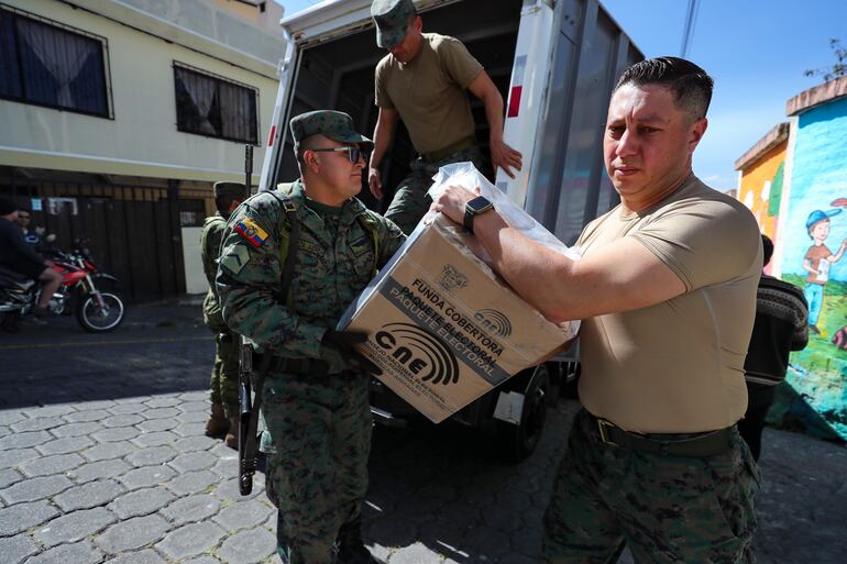 Militares distribuyen material electoral de cara a las elecciones presidenciales y legislativas extraordinarias de Ecuador, hoy, en Quito (Ecuador). El domingo los ecuatorianos acudirán a las urnas para designar a quien completará el período presidencial para el que fue elegido el conservador Guillermo Lasso (2021-2025).