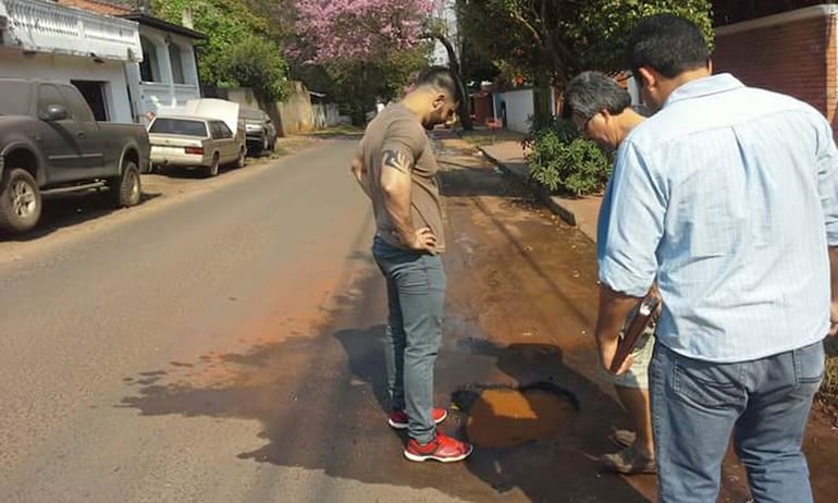 Óscar "Nenecho" Rodríguez, en 2016, mirando un bache sobre la calle Dr. Centurión. La foto está tomada de sus redes sociales, en las que afirmaba que la culpa era de Essap. La zona sigue hoy llena de baches.