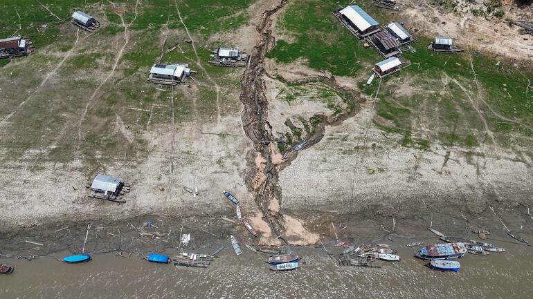 Fotografía aérea que muestra casas flotantes y embarcaciones encalladas en el río Manacapuru, uno de los afluentes del río Solimões, en Manacapuru, Amazonas (Brasil). Las sequías y crecidas extremas que se producen actualmente en varias partes del mundo son un “indicador” de las evoluciones futuras, con un ciclo del agua más irregular debido al cambio climático, advirtió la ONU el lunes.