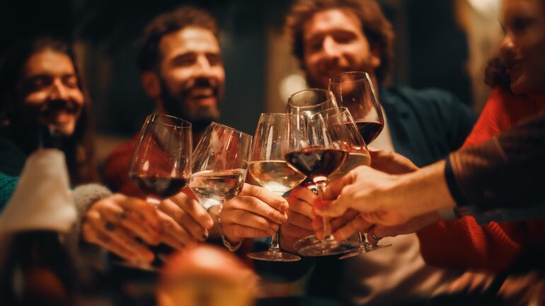 Un brindis con copas de vino blanco y tinto.