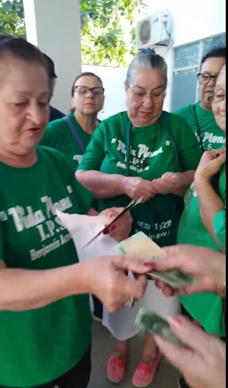 Captura de video del instante en el cual su madre procede a entregar a otra persona el dinero enviado por la legisladora, según el video publicado en redes sociales.