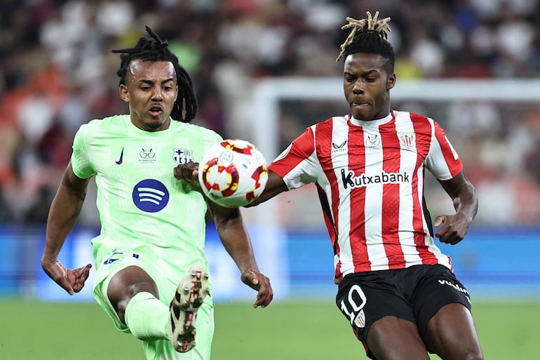 Barcelona's French defender #23 Jules Kounde fights for the ball with Athletic Bilbao's Spanish forward #10 Nico Williams during the Spanish Super Cup semi-final football match between Athletic Bilbao and Barcelona at the King Abdullah Sport City in Jeddah on January 8, 2025. (Photo by FADEL SENNA / AFP)