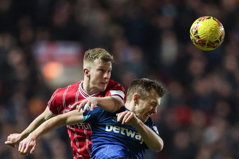 Ross McCrorie (i), mediocampista escocés del Bristol City, cabecea el balón superando en el salto a James Ward-Prowse, mediocampista inglés del West Ham, durante el partido celebrado ayer.