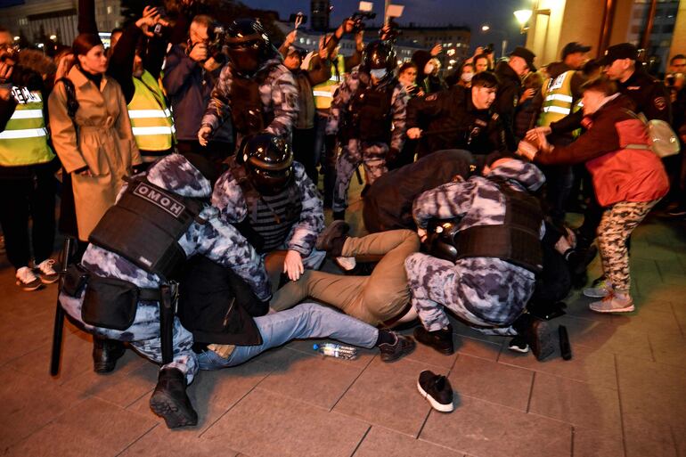 Policías detienen a manifestantes durante una protesta contra la movilización parcial de reservistas militares para guerra en Ucrania, el 21 de septiembre de 2022 en Moscú.