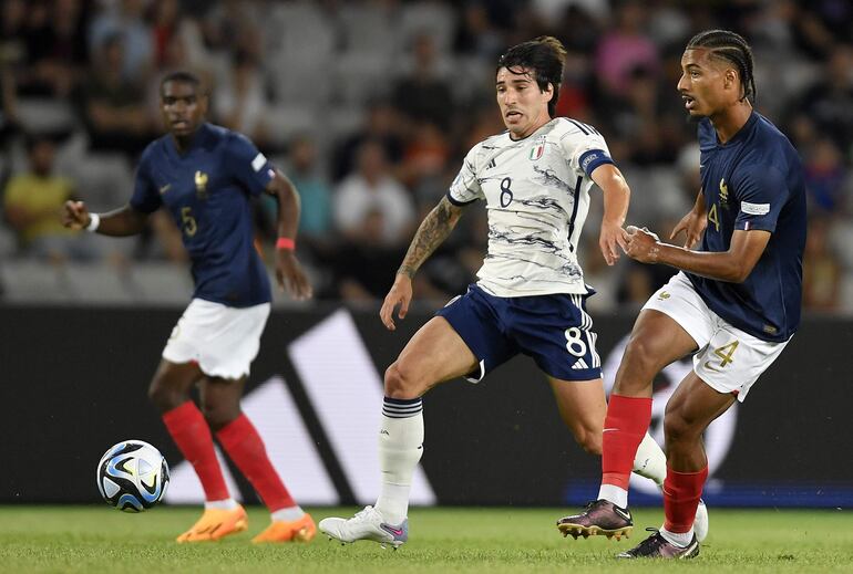 El italiano Sandro Tonali (c) disputa el balón con el francés Loic Bade, durante un partido por el Europeo Sub 21.  Tonali dejará el AC Milan para jugar en el Newcastle.