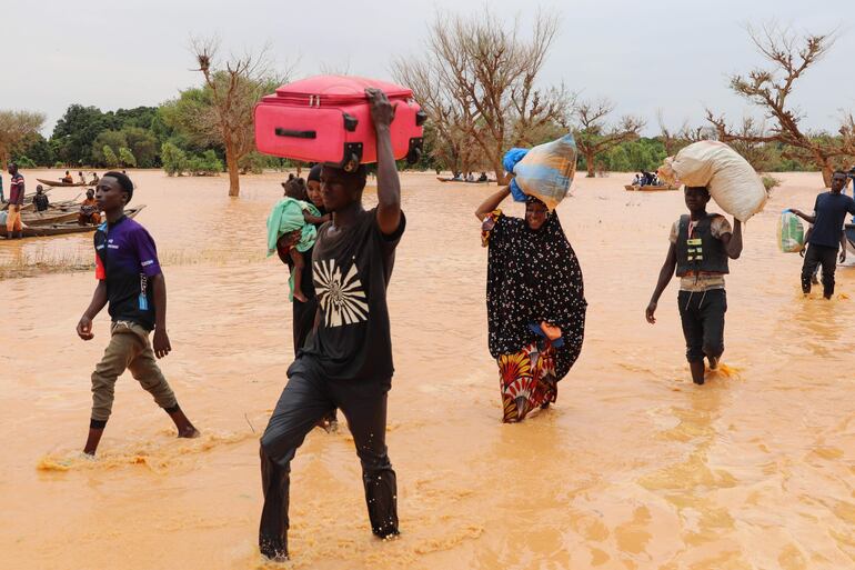 Varias personas cruzan una zona inundada en Niamey, Níger, el pasado 23 de agosto.