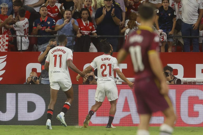 El delantero nigeriano del Sevilla Chidera Ejuke (c) celebra con sus compañeros tras anotar un tanto durante el partido de la jornada 7 de LaLiga EA Sports disputado este martes en el estadio Sánchez Pizjuán de Sevilla.