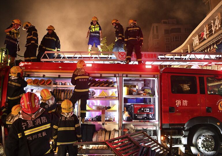 Bomberos trabajan para controlar las llamas tras la explosión en un restaurante en Yinchuan, en la Región Autónoma de Ningxia Hui, China, el 21 de junio de 2023.