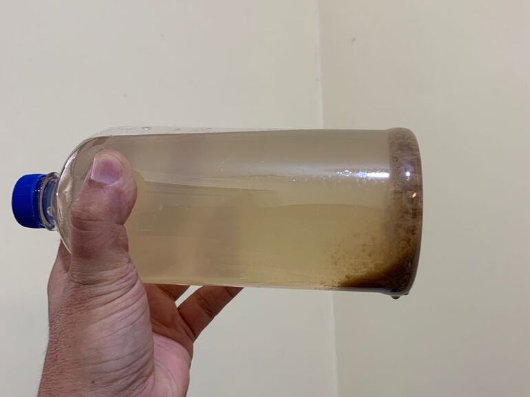 El agua cargada en una botella muestra arenilla.