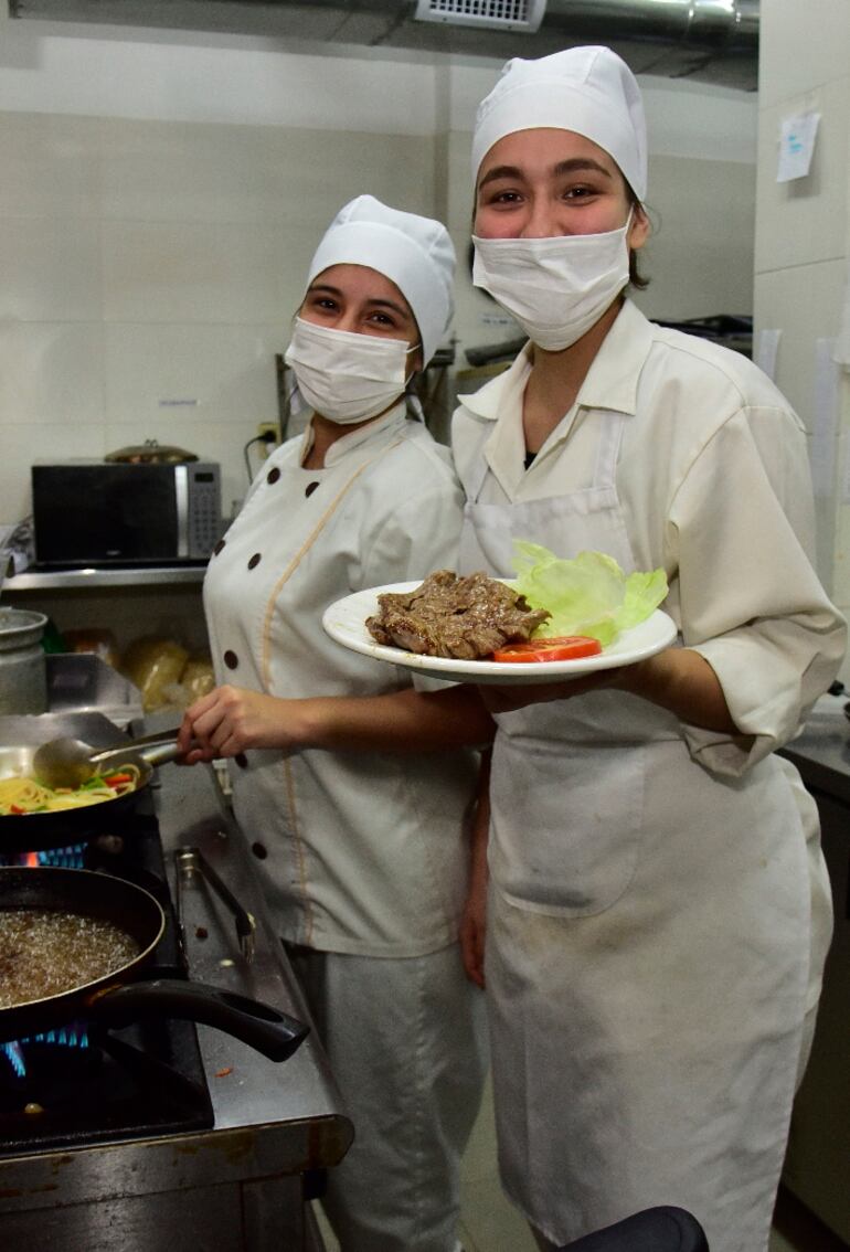 Chiara Francia y Luciana Melgarejo trabajan en la cocina del restaurante.