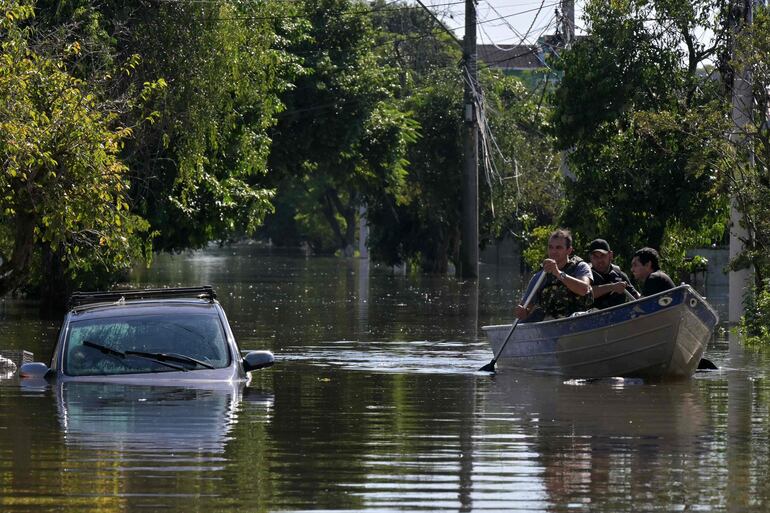 Locals move in boats following floodings due to heavy rains in Porto Alegre, Rio Grande do Sul state, Brazil on May 6, 2024. From top to bottom, rescuers scour buildings in Porto Alegre for inhabitants stuck in apartments or on rooftops as unprecedented flooding killed at least 78 people in the southern state, with dozens missing and some 115,000 forced to leave their homes. (Photo by NELSON ALMEIDA / AFP)