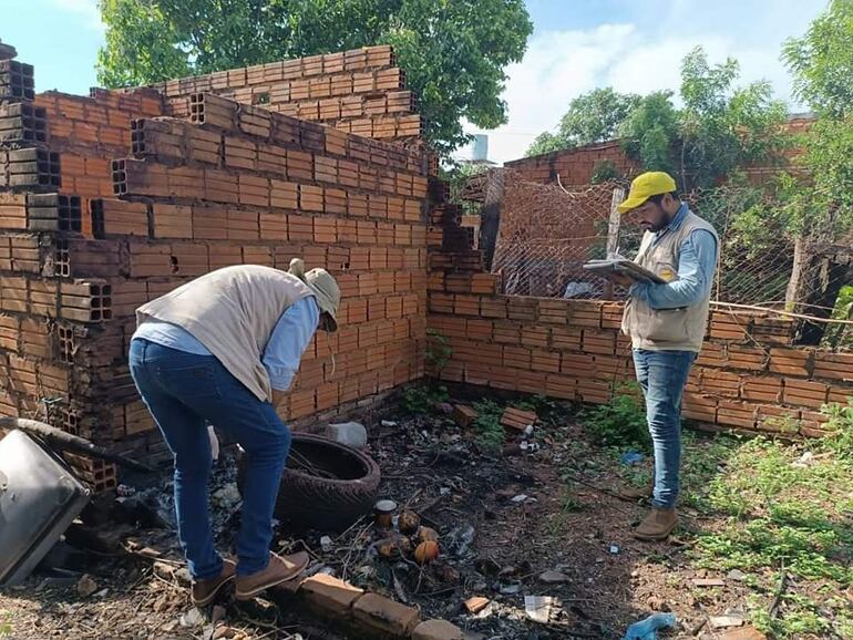 Funcionarios de Senepa observan basura acumulada en una vivienda. 