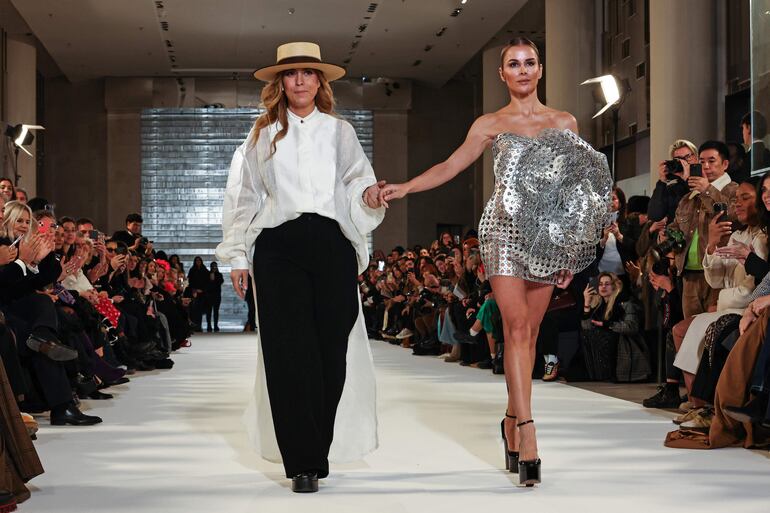 La diseñadora española Juana Martin (L) aparece en la pista con un modelo después de presentar su colección de Alta Costura Primavera/Verano 2024 durante la Semana de la Moda de París, en París, Francia.