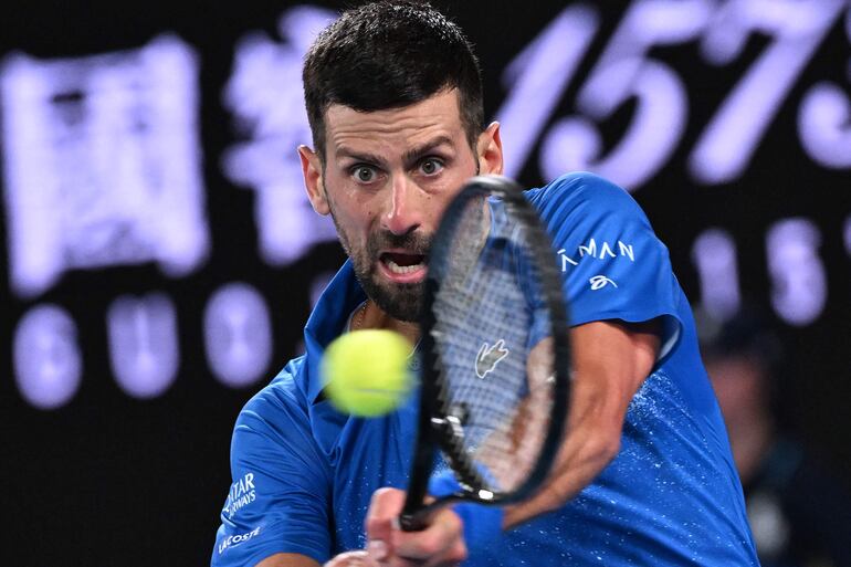 El serbio Novak Djokovic regresa contra el español Carlos Alcaraz durante el partido de cuartos de final de individuales masculinos el día 10 del torneo de tenis Abierto de Australia en Melbourne.