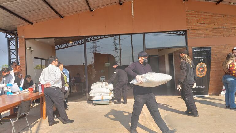 Agentes de la Senad transportando las bolsas de cocaína en polvo para ser quemadas.