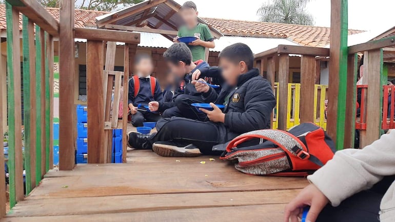 Niños almuerzan en un parquecito ante la falta de comedores en su escuela de Capiatá.