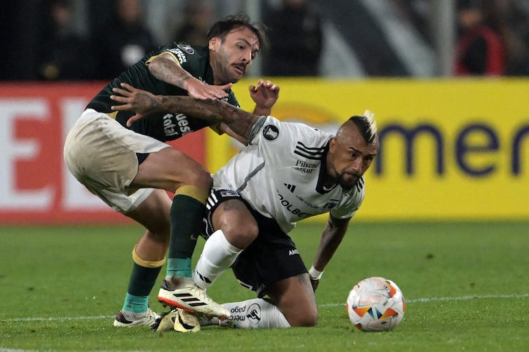 El chileno Arturo Vidal (d), futbolista de Colo Colo, disputa el balón con Sebastián Rodríguez, jugador de Alianza Lima, en un partido de la fase de grupos de la Copa Libertadores 2024 en el estadio Monumental David Arellano, en Santiago, Chile.