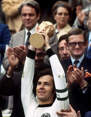 Una imagen de archivo fechada el 7 de julio de 1974 muestra al capitán de la selección alemana, Franz Beckenbauer, levantando el trofeo de la Copa del Mundo en el Estadio Olímpico de Múnich después de la final de la Copa del Mundo de 1974 entre Alemania y los Países Bajos, que Alemania ganó 2-1, reeditada el 8 de enero de 2024.