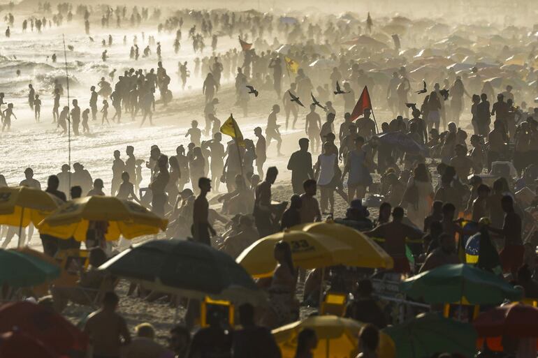 Personas observan el atardecer este miércoles, en la playa de Ipanema en Río de Janeiro (Brasil).