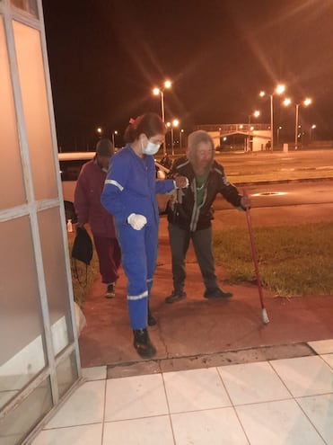 Una voluntaria de la Cruz Roja ayuda a un ingente ingresado al albergue transitorio municipal durante el presente operativo invierno para el rescate a indigentes en situación de calle.